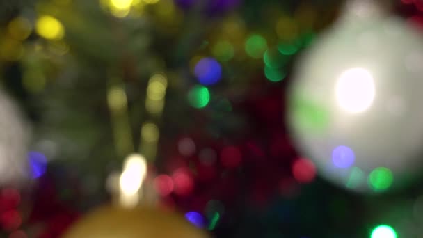 Arka plan bulanık. Çelengin renkli ışıkları Noel ağacında yanıp sönüyor. Yeni yıl.. — Stok video