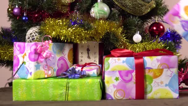 Una mano femminile mette scatole regalo sotto l'albero di Natale.Capodanno notte.Molti regali — Video Stock