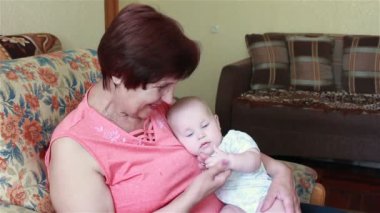 Yaşlı kadın bebekle oynuyor.