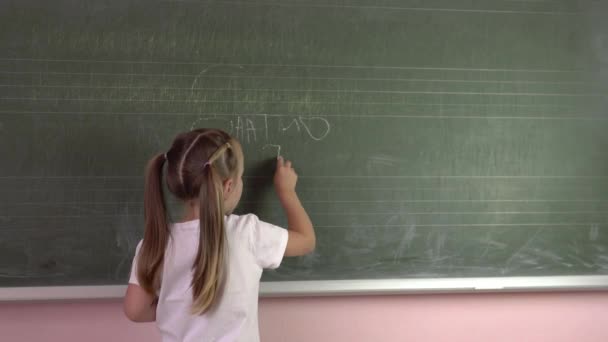 Küçük kız öğrenci okul tahtasına tebeşirle mektuplar yazıyor. Anaokulu eğitim 45 'liği — Stok video