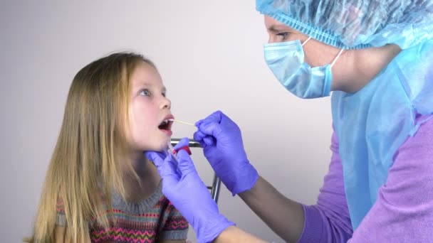 Az orvos egy kislány torkából vett mintát.. — Stock videók