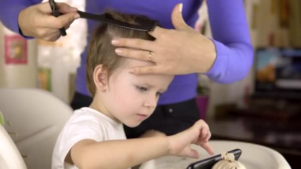 Ein Friseur Gibt Einem Gut Aussehenden Dreijährigen Jungen Hause Eine — Stockvideo
