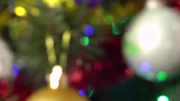 Verschwommener Hintergrund eines Weihnachtsbaums mit Kugeln und Girlanden blinkenden bunten Lichtern. — Stockvideo