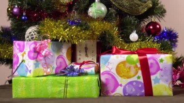 Bir kadın eli Noel ağacının altına hediye kutuları koyar. Yeni yıl gecesi. Bir sürü hediye.