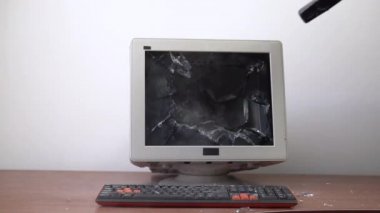 Masanın üzerinde duran eski monitör çekiçle ezilmiş..