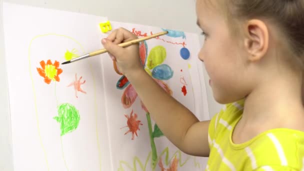 Porträtt av en liten vacker flicka som tecknar med färger på ett staffli. Förskola, målarlek.4k — Stockvideo