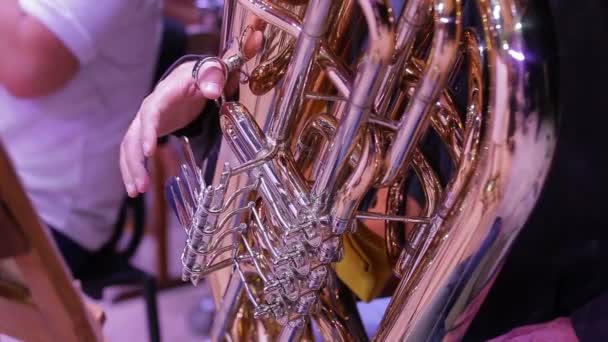 Gros plan sur les instruments à vent. Les musiciens pressent les doigts sur les valves du tuba.Outils en laiton. — Video