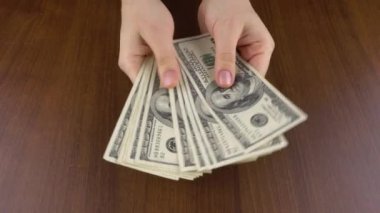 Kız masaya bir tomar dolar koyuyor ve adam onları eline alıyor. Nakit ödeme 4k