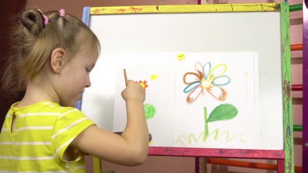 Pré-escolar, pintura lesson.Little menina cinco anos de idade desenha uma flor em aquarelas em um easel.4k — Vídeo de Stock