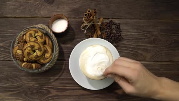 Een vrouwenhand die een cappuccino lepel roert. Veel melkschuim in de drank.. — Stockvideo