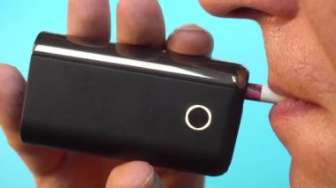 Elektronik sigara içen bir adam, kötü bir alışkanlık sağlık sorunlarına neden olur, yakın plan..