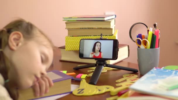 Joven hermosa maestra lleva una lección desde la pantalla de un teléfono inteligente mientras un estudiante está dormido.Collage — Vídeo de stock