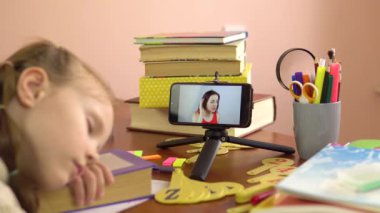 Genç ve güzel öğretmen bir öğrenci uyurken akıllı telefon ekranından ders alıyor. Kolaj.