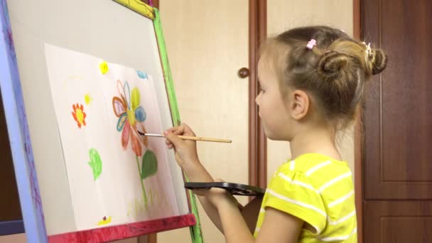 Κοριτσάκι πέντε ετών ζωγραφίζει ένα λουλούδι σε ακουαρέλες σε ένα ευκολί.Νηπιαγωγείο, μάθημα ζωγραφικής. — Αρχείο Βίντεο