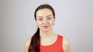 Genç ve güzel bir kadının portresi. Kameraya bakıp gülümsüyor..