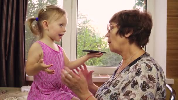 Uma menina de dois anos brinca com a avó.. — Vídeo de Stock