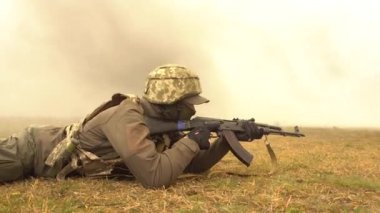 UKRAINE, Kharkiv, 11 Aralık 2021: Askeri tatbikat. Bir asker makineli tüfekle yatar ve nişan alır.