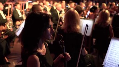 UKRAINE, KHARKIV, 20 Temmuz 2020: Bir kadın kemancı elinde bir kemanla orkestrada oturur. Bir duraklama bekliyorum.