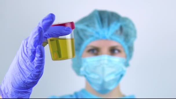 Female doctor shows urine test closeup. — Stockvideo