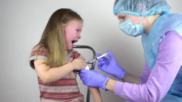 A doctor injects a vaccine to a little girl. The girl is afraid and crying. — Stock Video