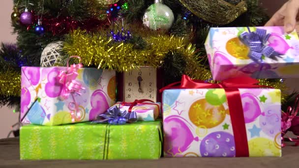 O mână de sex feminin pune cutii cadou sub copacul de Craciun.Noaptea de Anul Nou. Multe cadouri 4k — Videoclip de stoc