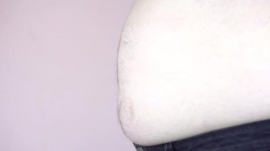 Koca göbekli bir adam. Obezite. Aşırı yeme sorunu. Yakın plan..