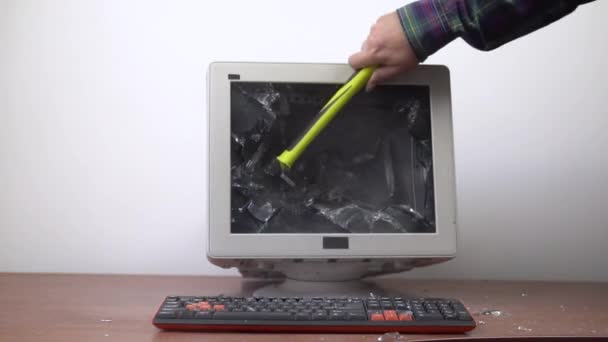 Der alte Monitor, der auf dem Tisch steht, wird mit einem Hammer zertrümmert.. — Stockvideo