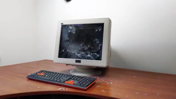 Der alte Monitor, der auf dem Tisch steht, wird mit einem Hammer zertrümmert. — Stockvideo