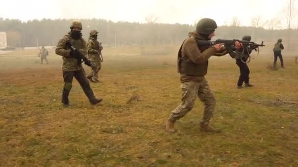 UKRAINE, Kharkiv, December 11, 2021: Military exercises. Gruppa soldiers with machine guns are walking across the field. — Stockvideo
