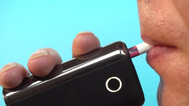 Un hombre fuma un cigarrillo electrónico, un mal hábito causa problemas de salud, primer plano. — Vídeo de stock