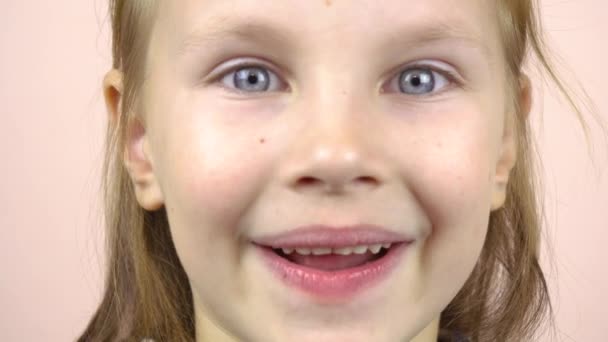 Close-up of the face of a little girl who shows her mouth with fallen milk teeth, grimaces. — Stock Video