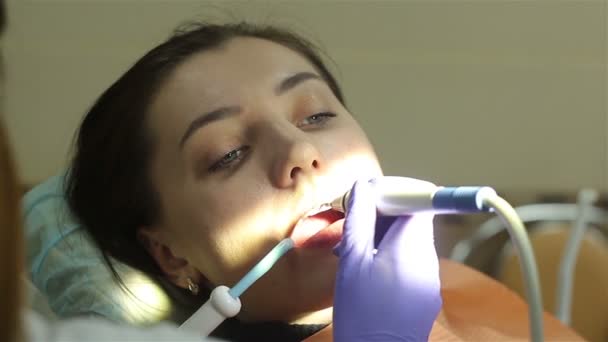 Young woman in dental clinic. Teeth cleaning. — Stockvideo