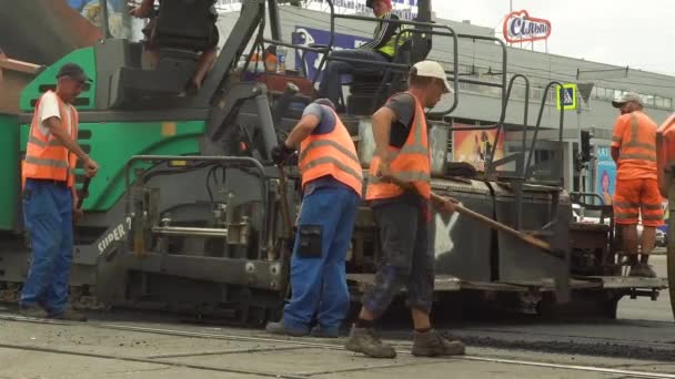 UKRAINE, KHARKOV, JULY 30, 2020: Road repair. A team of workers is laying asphalt. Asphalt paver. — Wideo stockowe