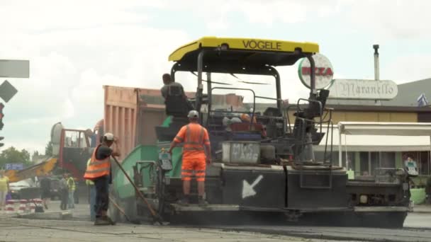 UKRAINE, KHARKOV, JULY 30, 2020: Road repair. A team of workers is laying asphalt. Asphalt paver. — Stock videók