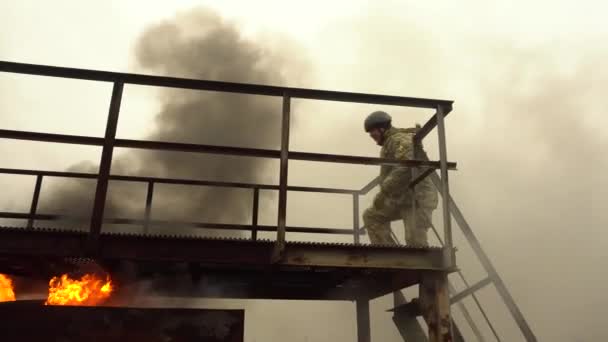 UCRANIA, Kharkiv, 11 de diciembre de 2021: Ejercicios militares. Un hombre de uniforme camina a través de una carrera de obstáculos en humo. — Vídeo de stock