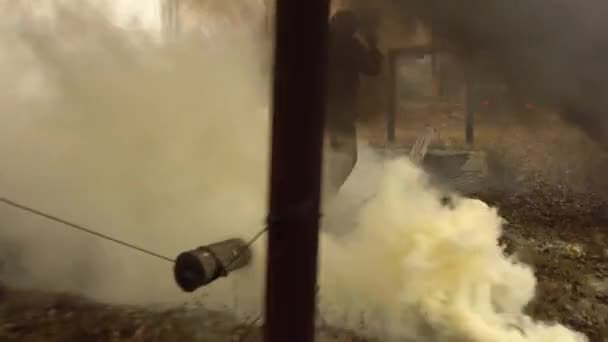 UKRAINE, Kharkiv, 11 december 2021: Militära övningar, passerar en hinderbana. En man i uniform går över en gungande stock över en grop. Mycket rök. Branden brinner. — Stockvideo