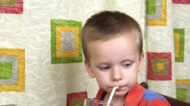 Küçük bir çocuk bardaktan süt içiyor..