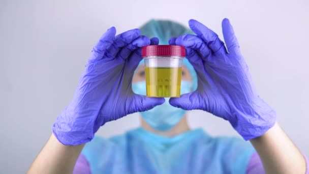 Female doctor shows container with urine tests. — Stock Video