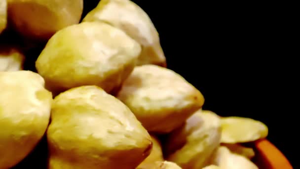 Concept Macro Video Candlenuts Pile Black Background — Stock Video
