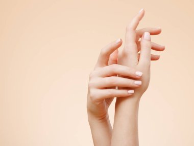 Güzel kadın eller. Spa ve manikür kavramı. Fransız manikür ile eller. Yumuşak cilt, Cilt Bakımı kavramı. Güzellik çivi. bej renkli arka plan üzerinde