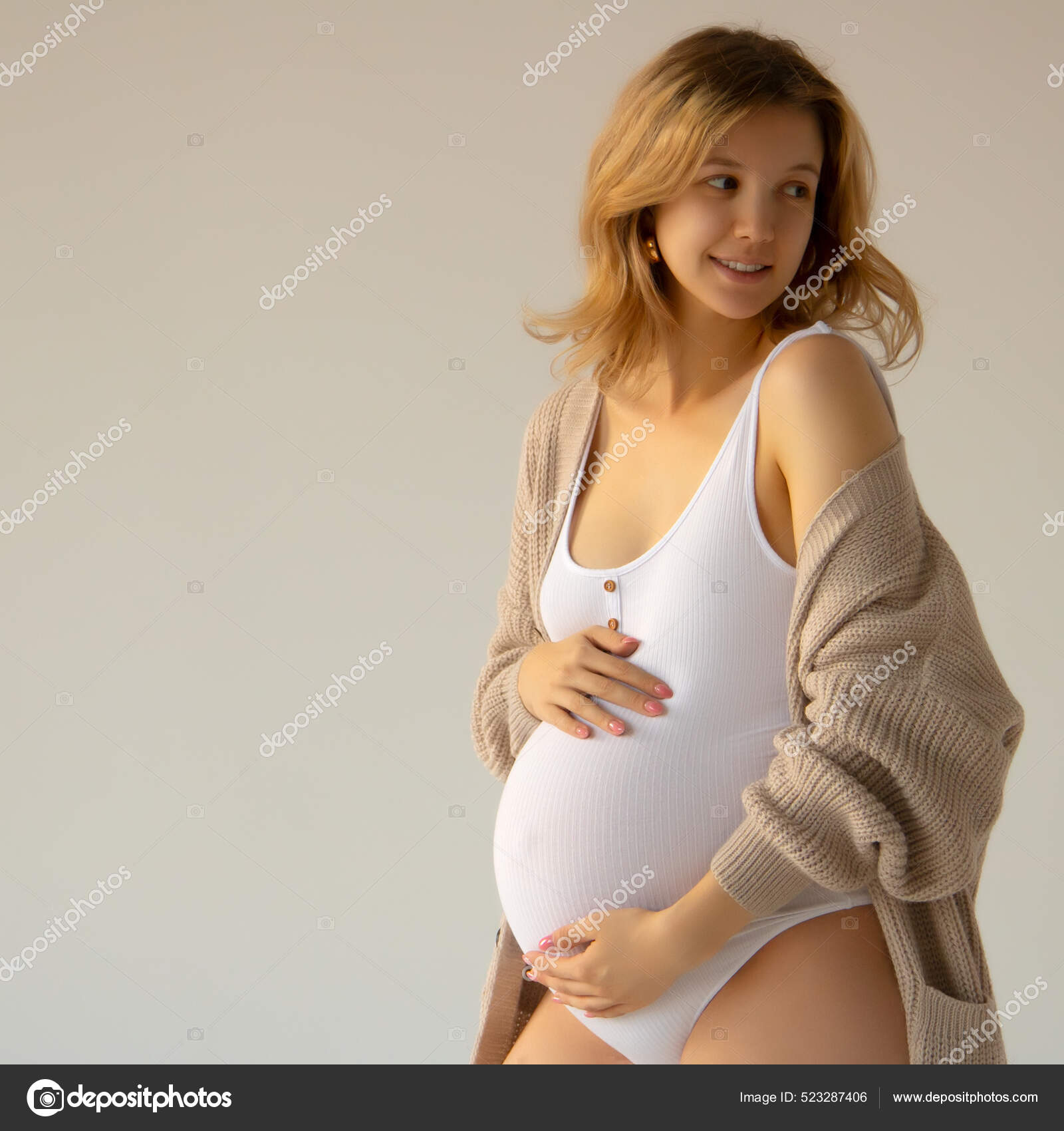 Hermosa mujer embarazada en traje blanco la belleza del cuerpo