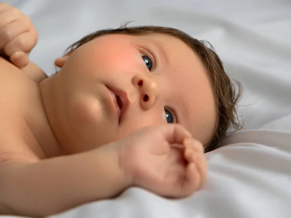 Újszülött baba fehér takaróba csomagolva. Gyönyörű portré egy 7 napos, egy hetes kislányról. Baba feküdt vissza fehér háttér — Stock Fotó