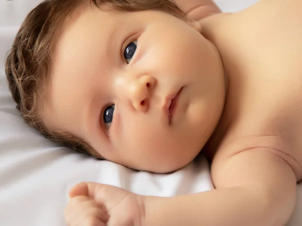 하얀 담요를 두른 갓 태어난 아기. 7 일된, 일 주일된 어린 소녀의 아름다운 사진. 하얀 배경 위에 누워 있는 아기 — 스톡 사진