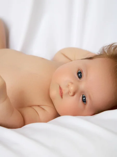 Bebê recém-nascido em um envoltório em cobertor branco. Belo retrato da menina criança 7 dias, uma semana de idade. Bebê deitado de costas no fundo branco — Fotografia de Stock