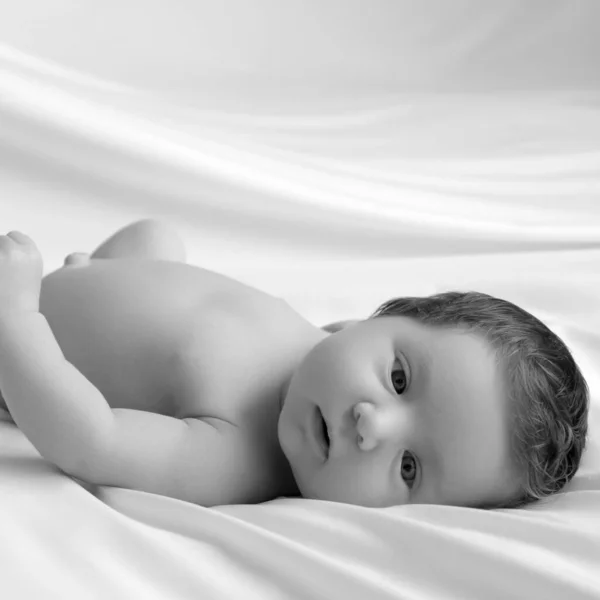 Новорожденный в белом одеяле. Портрет маленькой девочки 7 дней и одной недели. Ребенок лежит на спине на белом фоне — стоковое фото