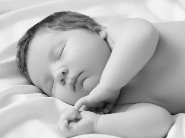 Ein kleines Mädchen mit mildem Gesicht im Schlaf. Kleines Mädchen, schlafend auf weißer Decke. Schönes Porträt des kleinen Mädchens 14 Tage, zwei Wochen alt. Mutterschaft — Stockfoto