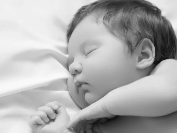 Ein kleines Mädchen mit mildem Gesicht im Schlaf. Kleines Mädchen, schlafend auf weißer Decke. Schönes Porträt des kleinen Mädchens 14 Tage, zwei Wochen alt. Mutterschaft — Stockfoto