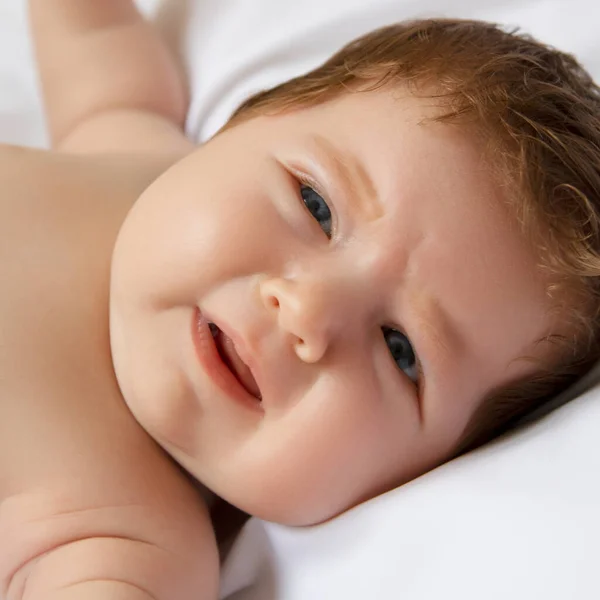 Egy 1 hónapos baba hazudik és sír, mert éhes egy fehér matracon. A csecsemő rosszul érzi magát az álmosság miatt. Újszülött fehér takarón. Gyönyörű portré a kislányról — Stock Fotó
