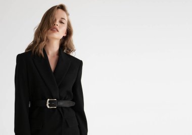 Doğal görünüş. Güzel model kadın. Gri arka planda poz veren genç ve güzel bir model ile model test portresi. Siyah ceketli sarışın bir kadın. Doğal makyaj.