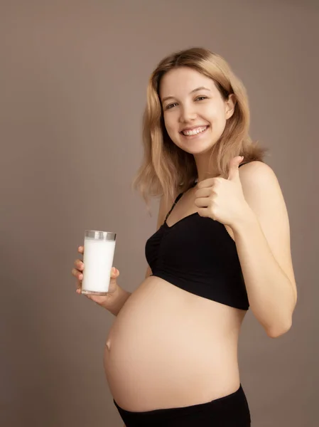 Porträt einer schönen schwangeren Frau mit einem Glas Milch. Frühstück. Das Konzept der sinnvollen Ernährung schwanger. Seitenansicht. Schwangere trinkt Milch — Stockfoto